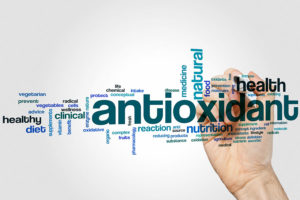Anioxidant - a hand writing the word Antioxidant over a transparent surface