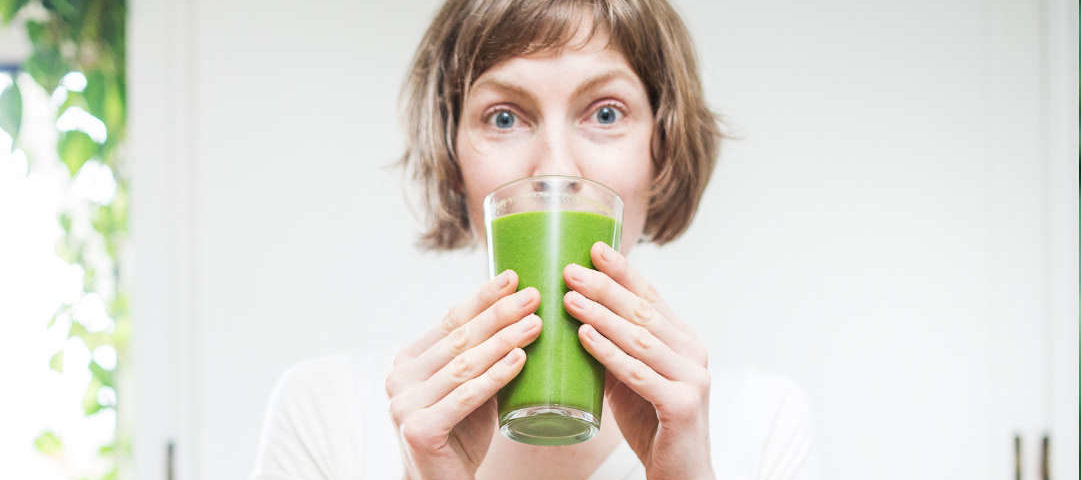 Top 10 frozen fruit pulps for wholesale. Image of a woman drinking a glass of Green Juice