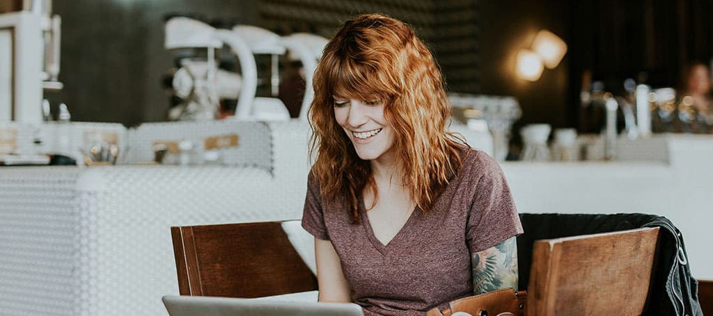 woman sitting in a cafeteria using her laptop