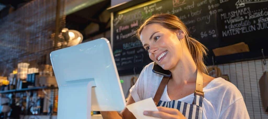 Restaurant owner talking on the phone inside her business