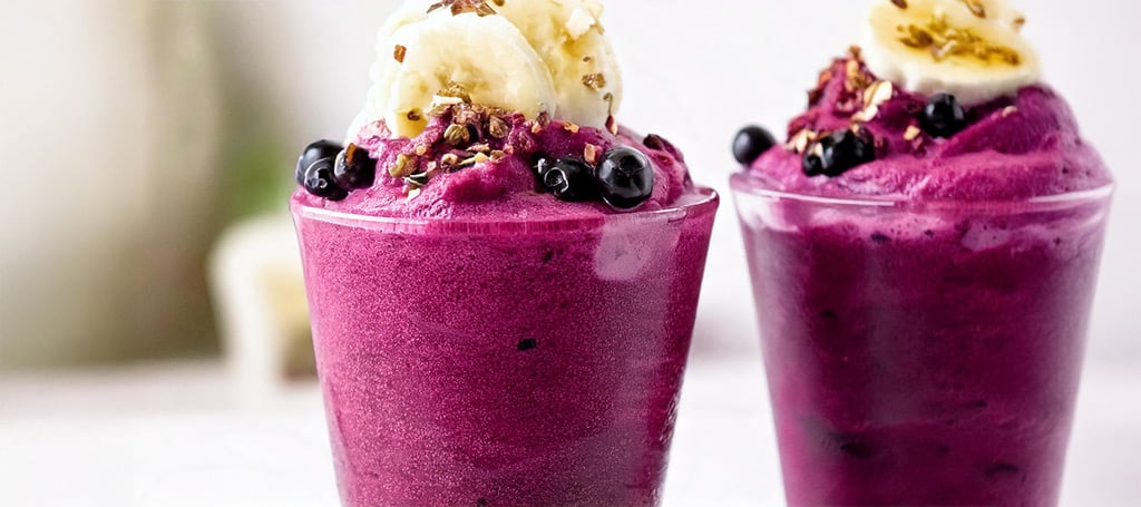 Two glasses of açaí sorbet, with banana, blueberries and granola